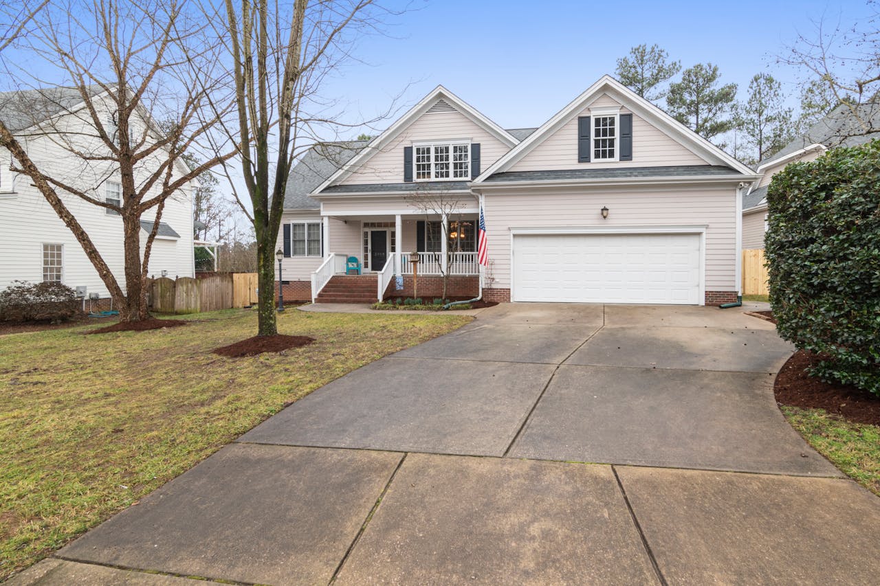 A well-maintained suburban house exterior with a large driveway, perfect for real estate listings.